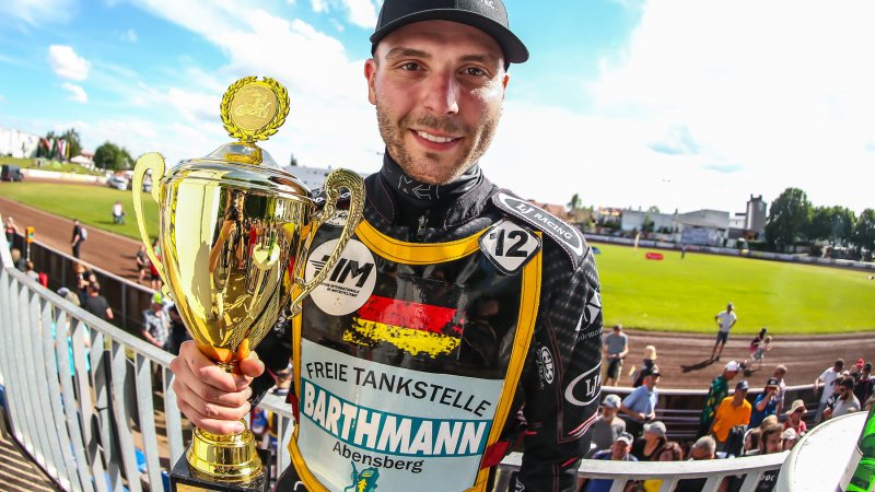 Sieger mit Pokal am Bahnrand