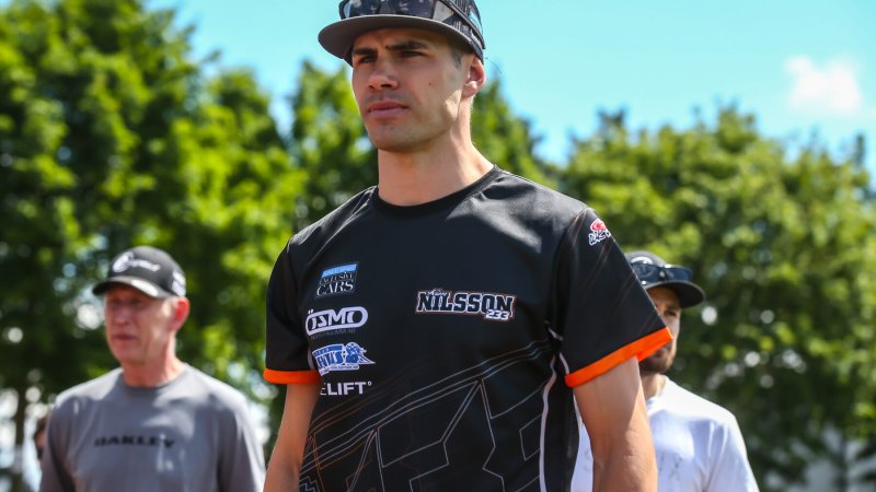 Fahrer im Teamshirt mit Kappe im Fahrerlager